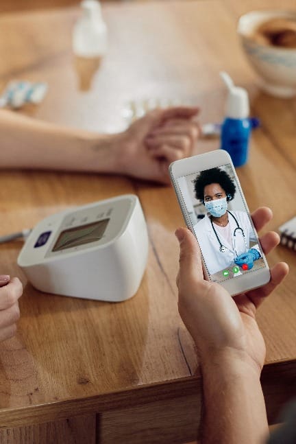 Close-up of black female doctor advising her patients who are measuring blood pressure at home during coronavirus pandemic.